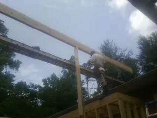 Carpenter setting a ridge beam over a new addition frame — Ice Dam Removal by Roofing Brothers in Polo